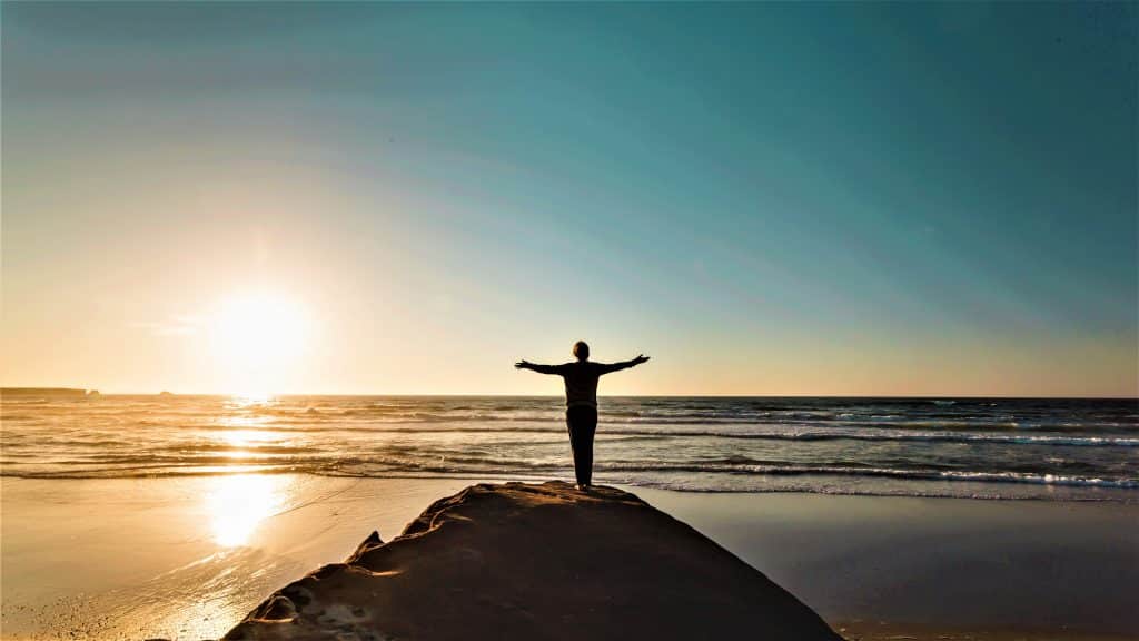 Nehemiah Project is Expanding Our Brand photo of woman on mountain top throwing wide her arms.